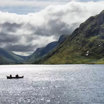 Two people on a boat sailing in the Glenveagh National Park
