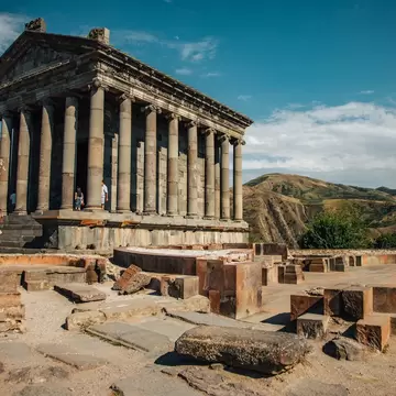 The impressive columns of the Garni Temple in Armenia, with rugged hills behind.