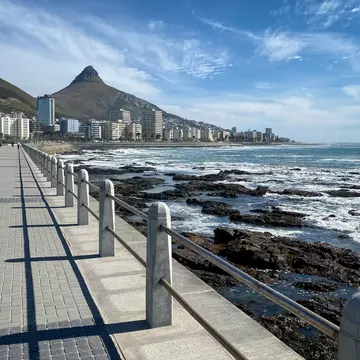 Sceniv view of Sea Point Promenade with scenic view Seapoint district and Lion"u2019s Head Peak, Cape Town, South Africa against blue sky