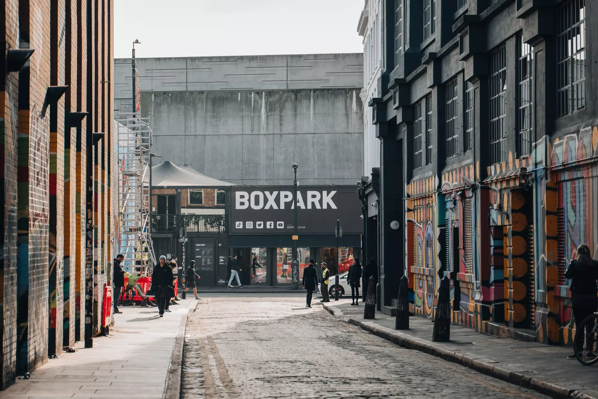 View of Boxpark Shoreditch, a shipping container mall for independent fashion and lifestyle stores and cafes, from a nearby street, selective focus on the background.