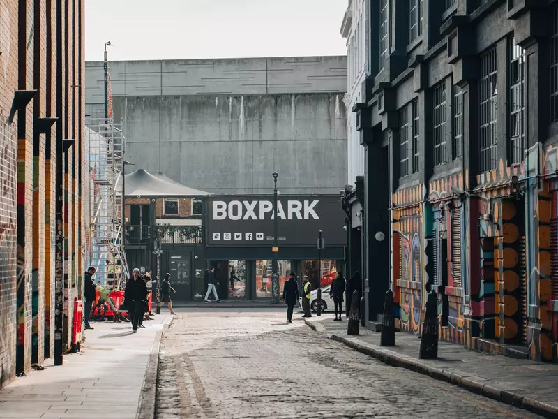 View of Boxpark Shoreditch, a shipping container mall for independent fashion and lifestyle stores and cafes, from a nearby street, selective focus on the background.