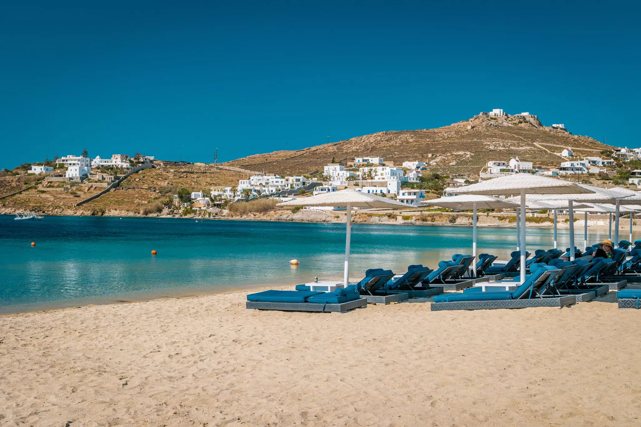 Mykonos island, famous Ornos beach organized with sun beds emerald clear water beach of Ornos in island of Mykonos, Cyclades, Greece  License Type: media  Download Time: 2023-01-28T13:20:17.000Z  User: Norma.PrauseBrewer_LonelyPlanet  Is Editorial: No  purchase_order:   