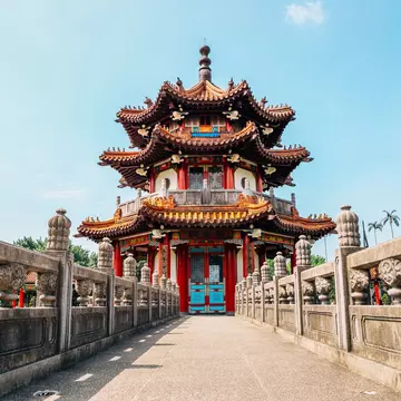 A walkway to a red-roofed pagoda.
