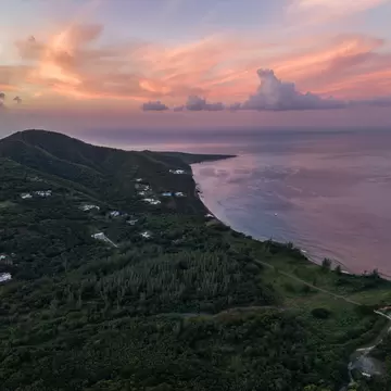A sunrise aerial view of the southern part of Montserrat with coastline and pink sky