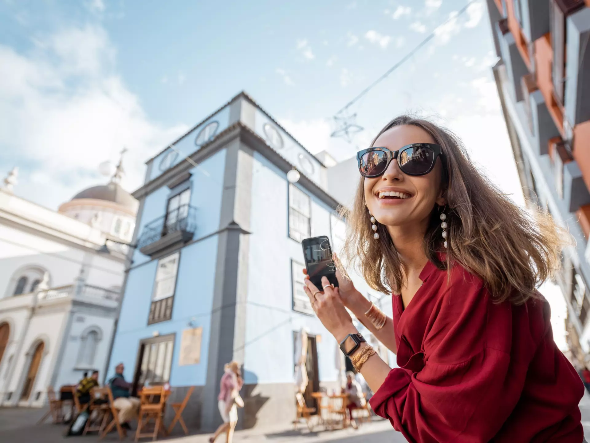 White woman smiling in La Laguna old town city on Tenerife, Spain with a blurry historic building in the background
