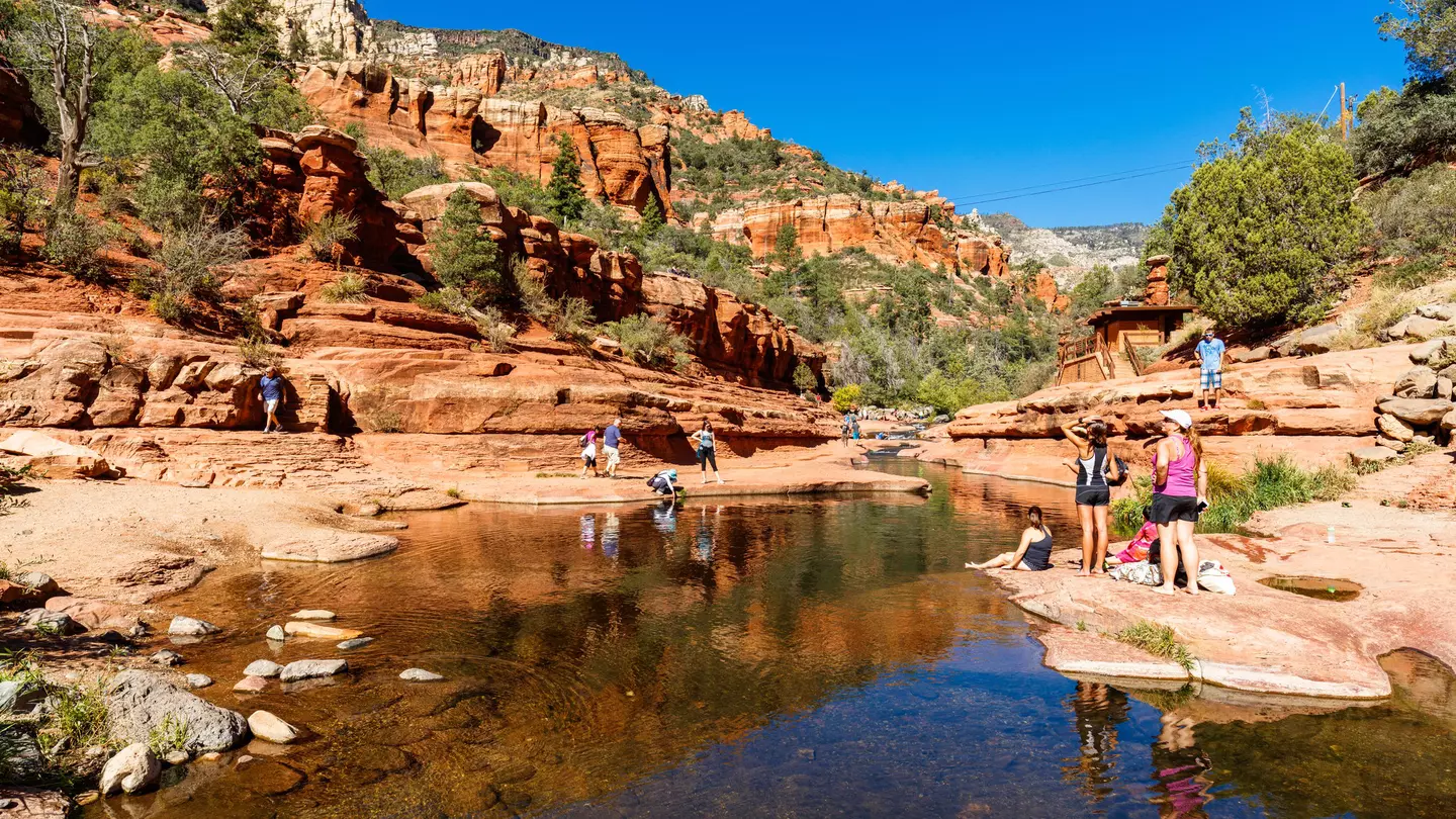 Visitors enjoying the beauty of Slide Rock State Park with its natural rock water slides in the Oak Creek Canyon near Sedona.