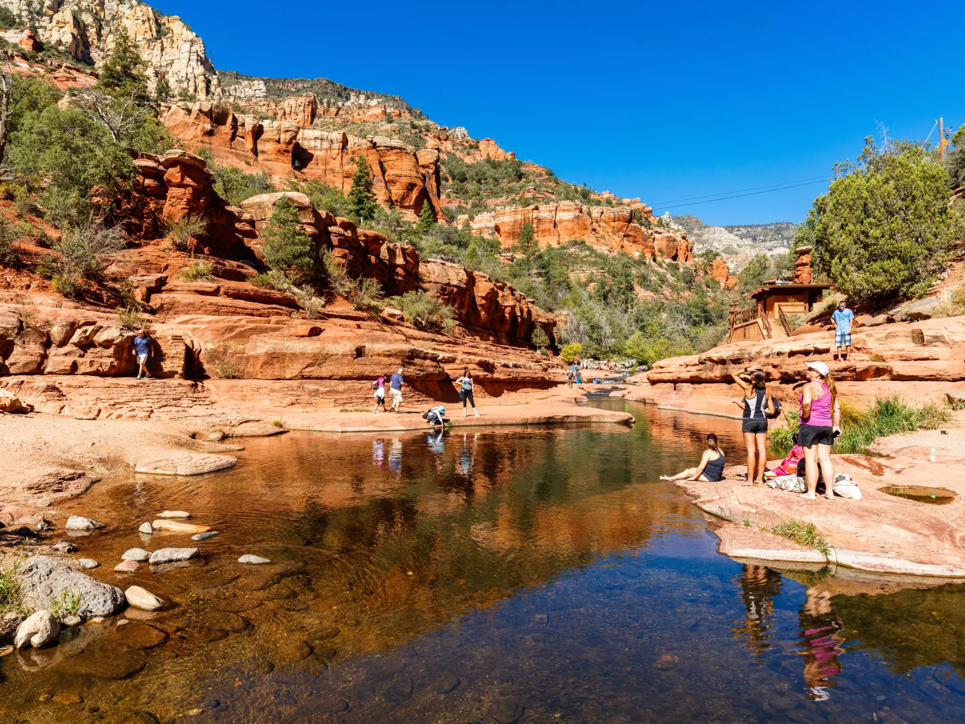 Visitors enjoying the beauty of Slide Rock State Park with its natural rock water slides in the Oak Creek Canyon near Sedona.