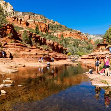Visitors enjoying the beauty of Slide Rock State Park with its natural rock water slides in the Oak Creek Canyon near Sedona.