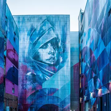 Wide Open Walls mural of a person's face in blue and purple, Sacramento, California