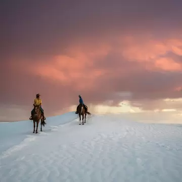 Men on horse back in White Sands