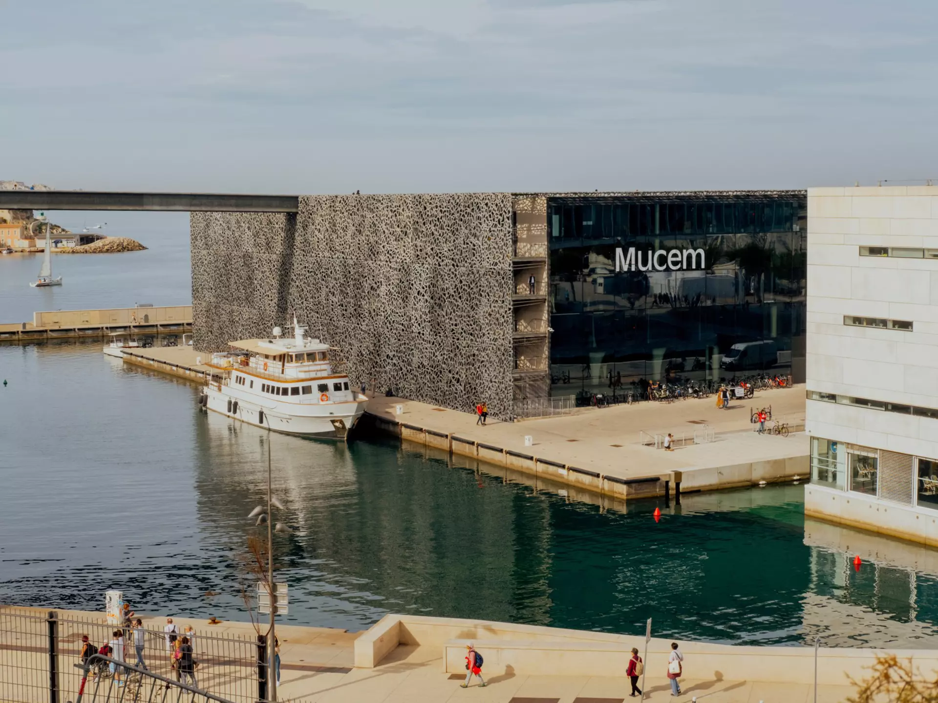 A boat is docked near a portside museum building.