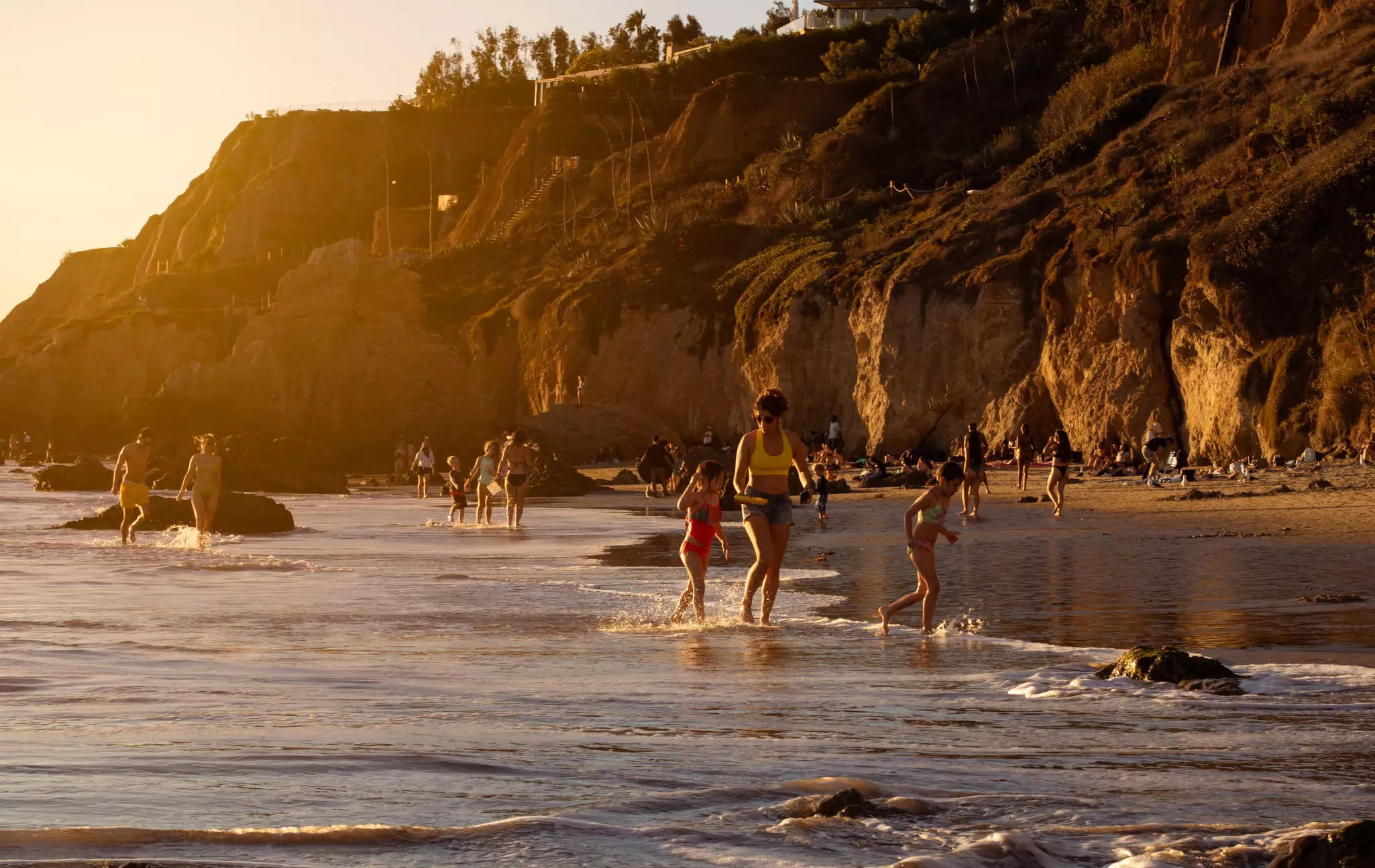 Sunset view of people having fun on El Matador Beach, Malibu, California