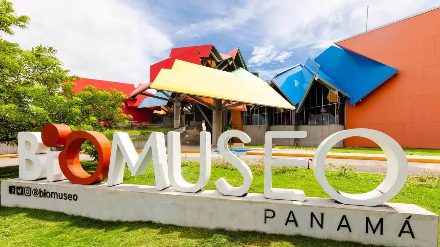 Exterior shot of the colorful BioMuseo in Panama. There is a BioMuseo sign on the grass