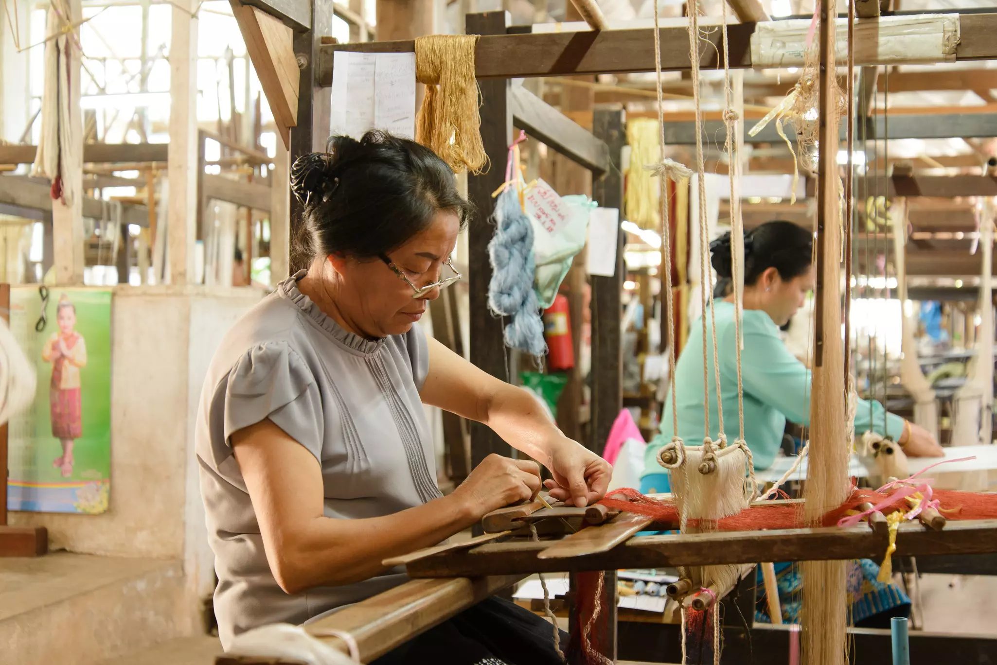 Weavers work at traditional looms.