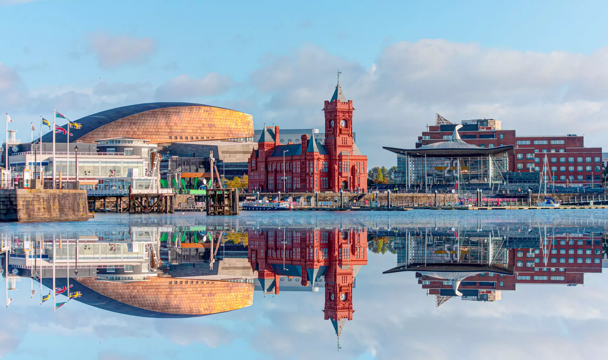 A city waterfront with a large red building and clock.
