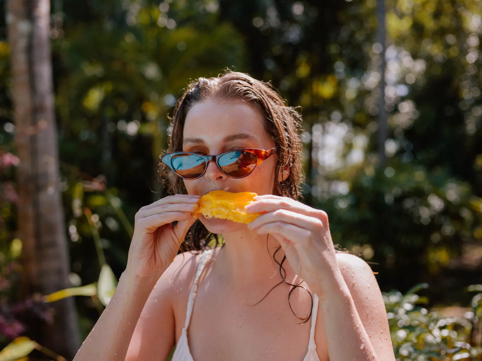 Young Woman Eating Mango On Vacation