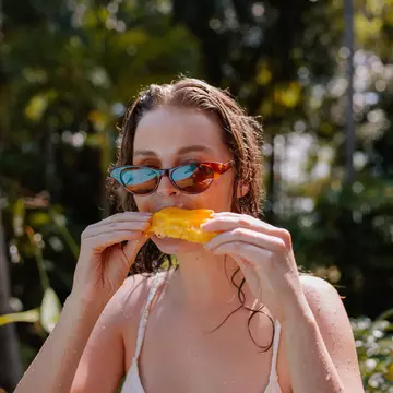 Young Woman Eating Mango On Vacation