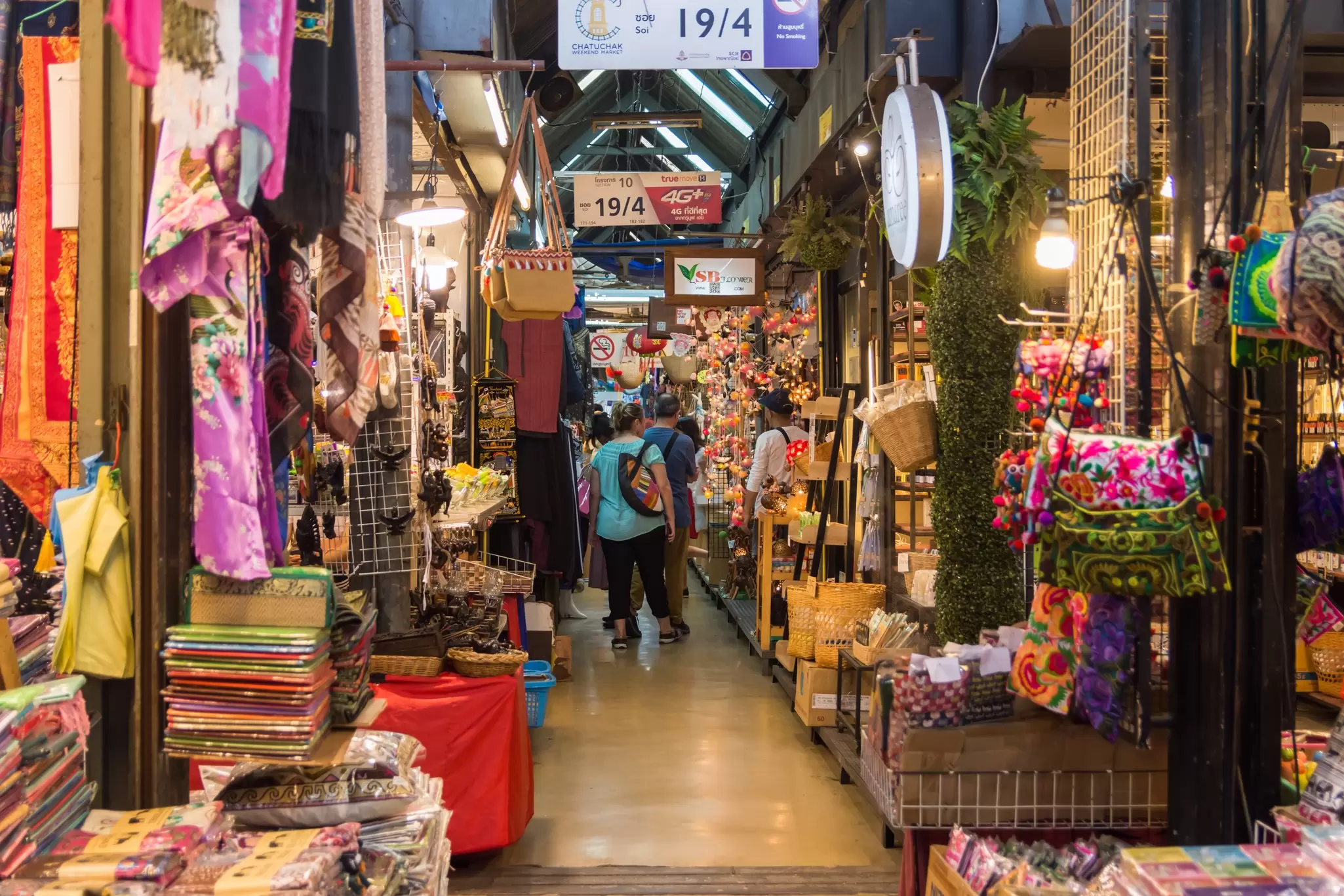 People shopping and exploring around Chatuchak Weekend Market in Bangkok, Thailand.