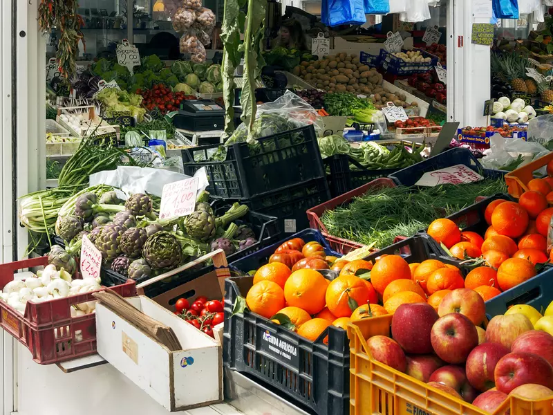 A greengrocer stall packed with fruit and vegetables at an indoor market