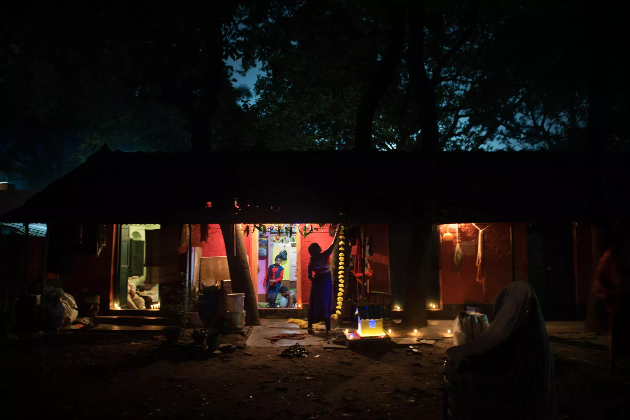 A women hangs decorations up on her home at night