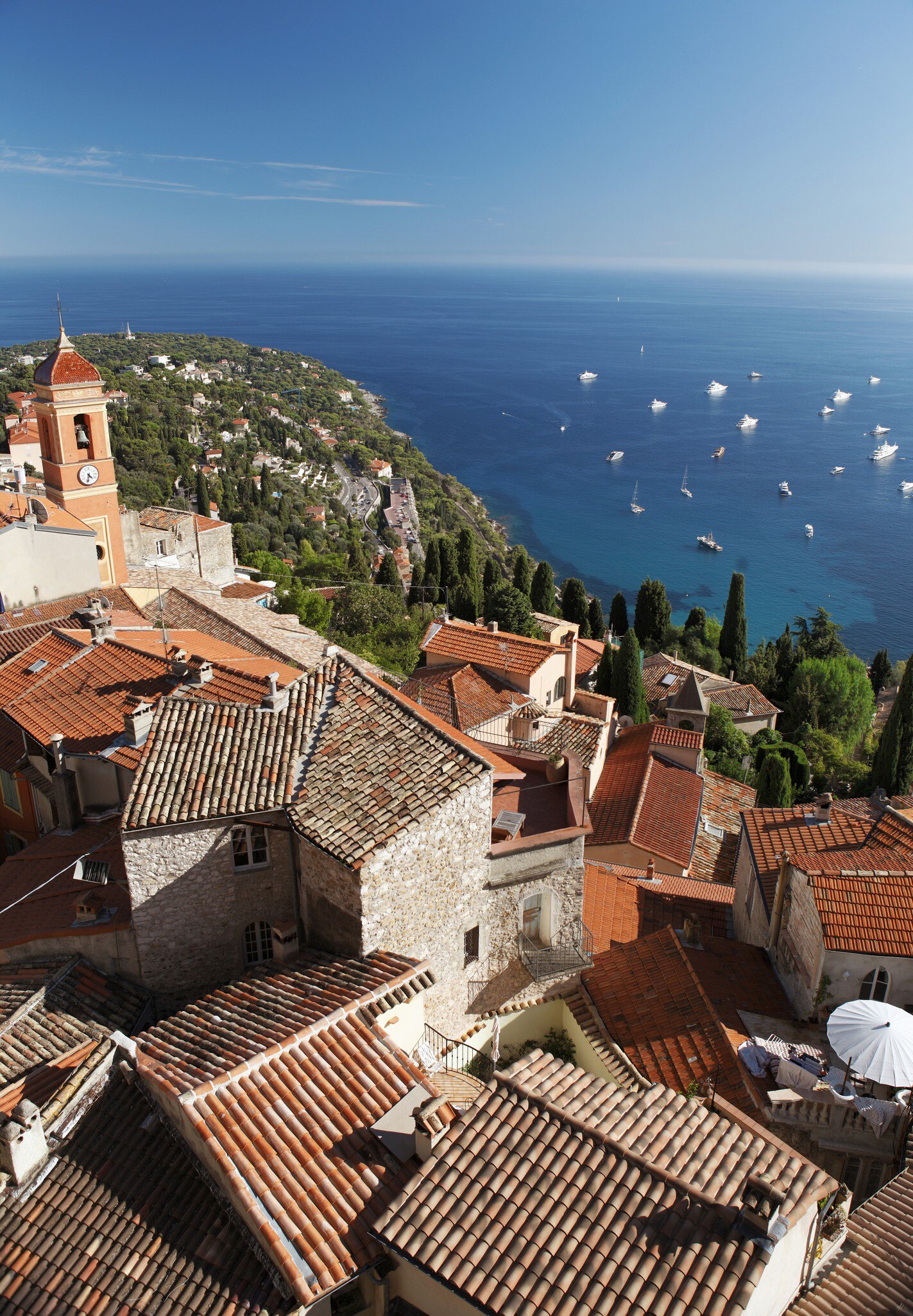 Terracotta tiled roofs of houses in hillside village with Château de Roquebrune. Nice, France.