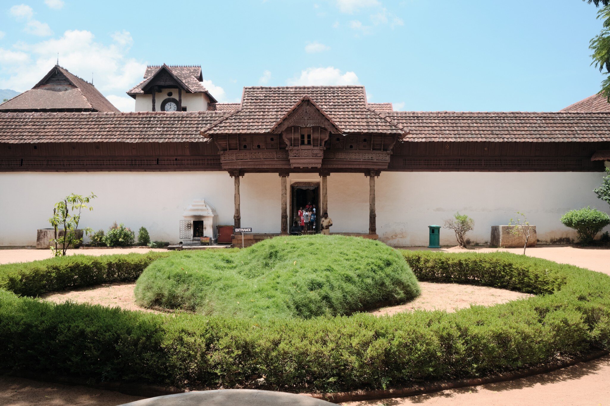  :Front entrance of Padmanabhapuram Palace with wooden portico carved pillars and ornamental garden. Kerala, India.