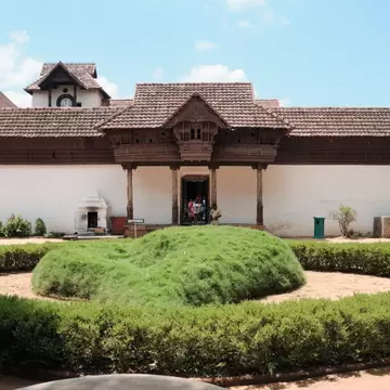  :Front entrance of Padmanabhapuram Palace with wooden portico carved pillars and ornamental garden. Kerala, India.