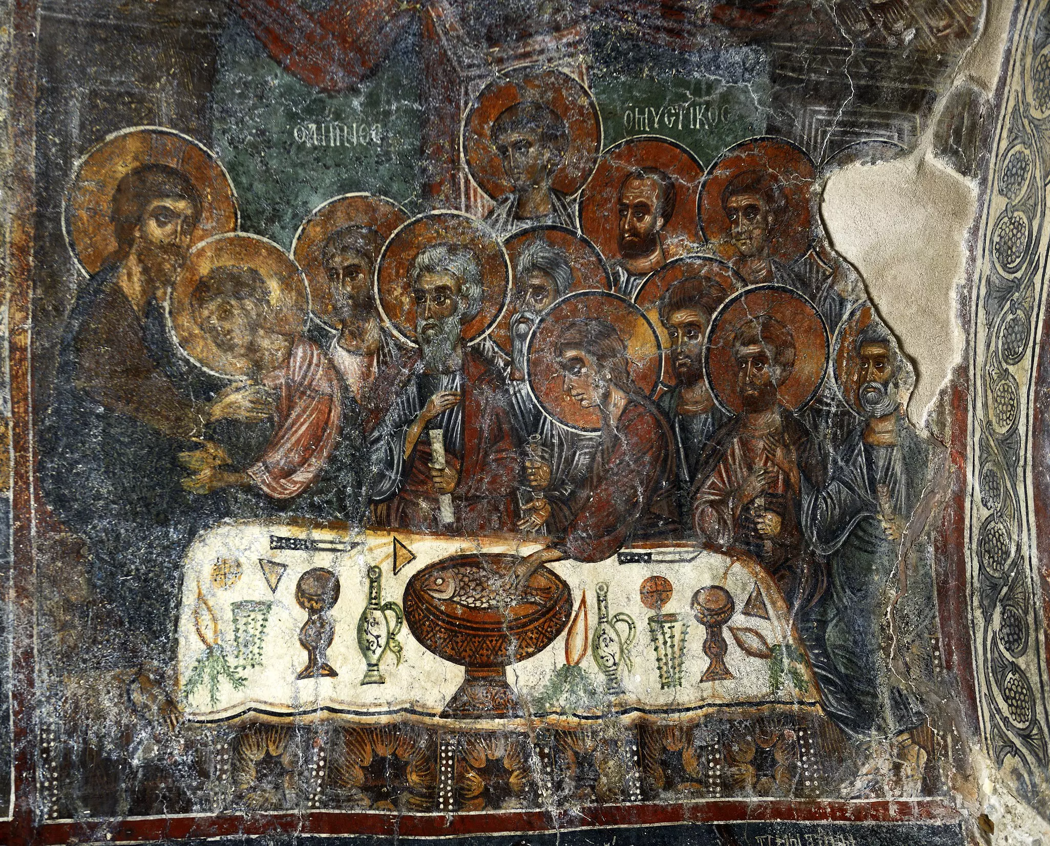 A frescoed scene on a painted wall depicts saints around a table with large haloes, Church of Panagia Kera, Crete. 