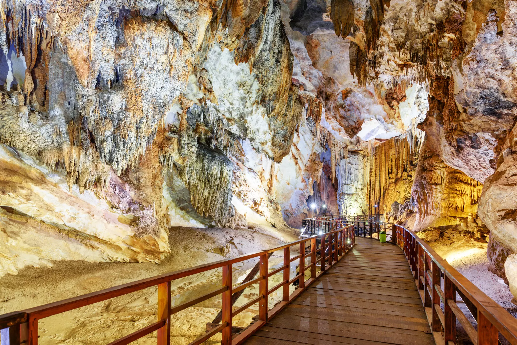 A wooden walkway leads through a cave system with many karst peaks.