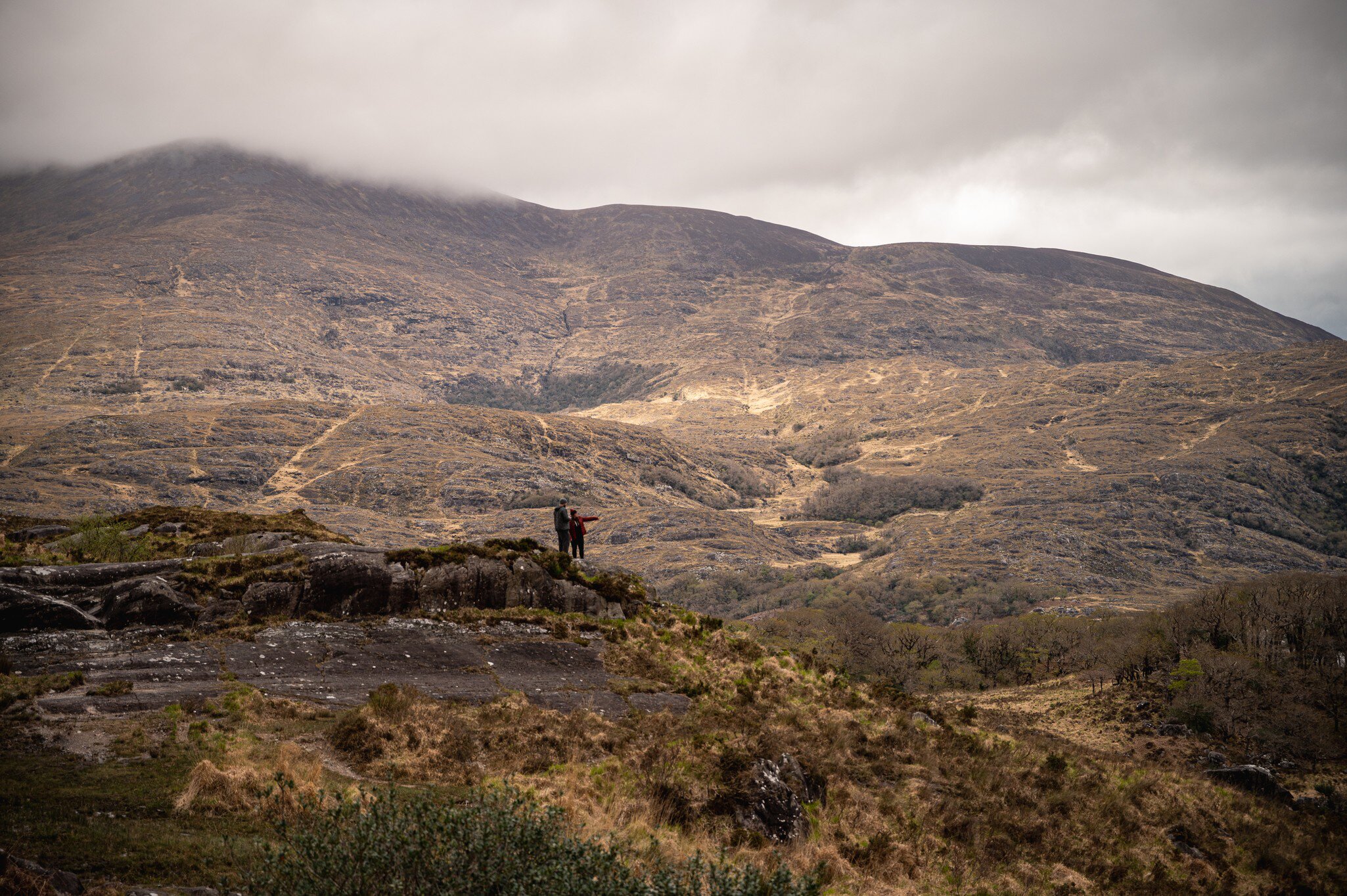 Landscape of Killarney National Park, Kerry, Ireland. Two people standing on hill and looking out.