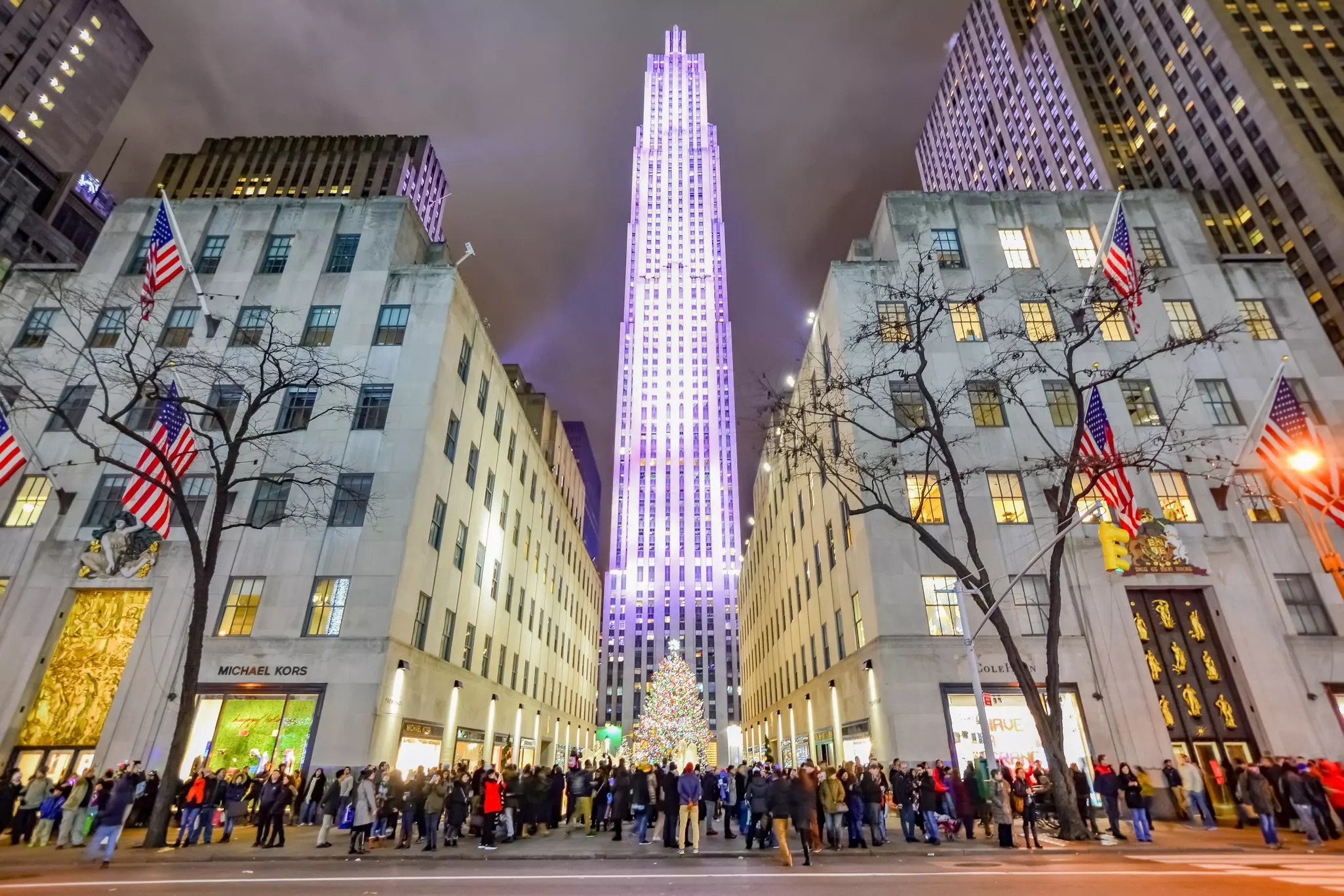 A distant shot of people skating at Rockefeller Center with the Christmas tree in view