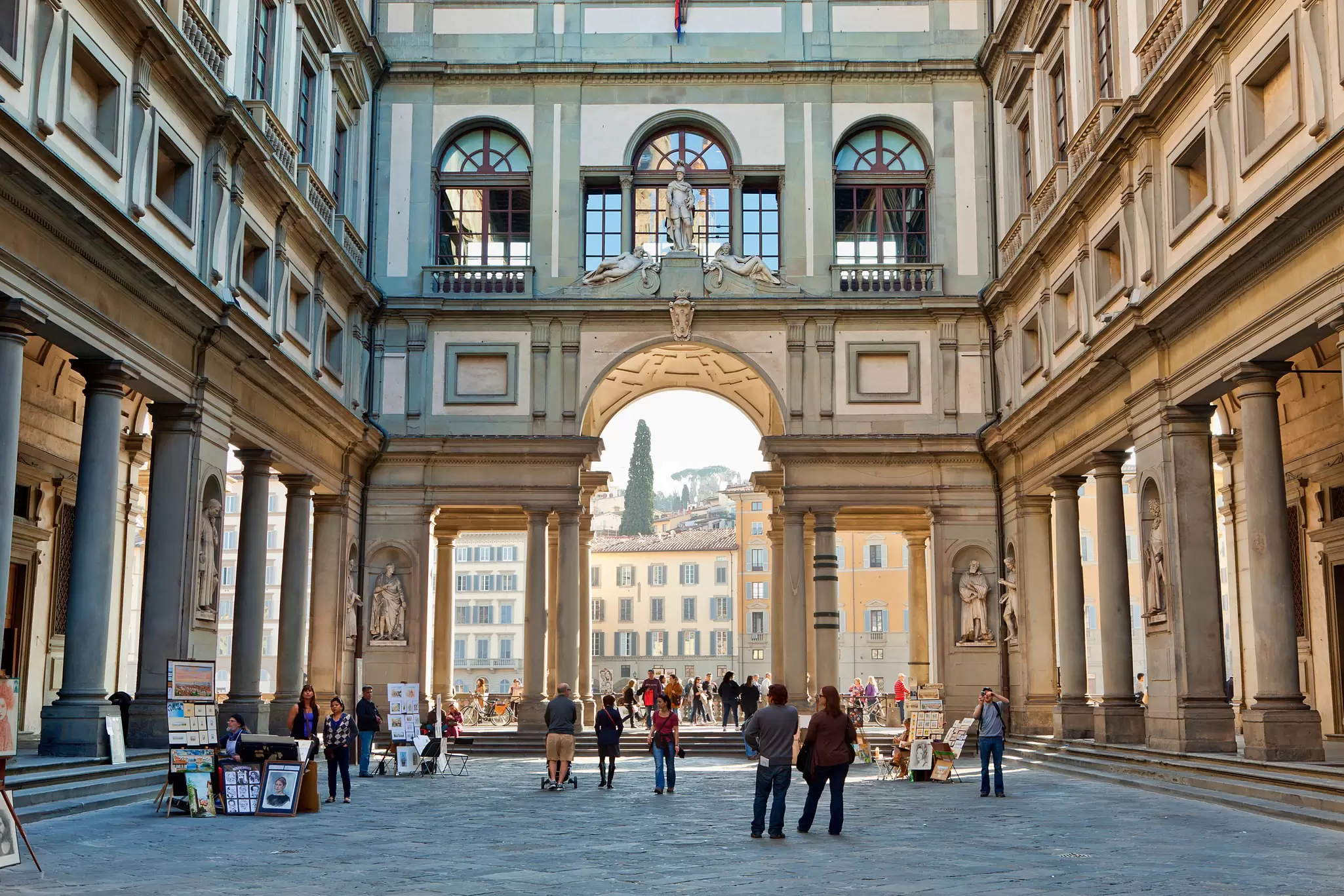 People walking through the Vasari Corridor at the Galleria degli Uffizi in Florence, Italy.