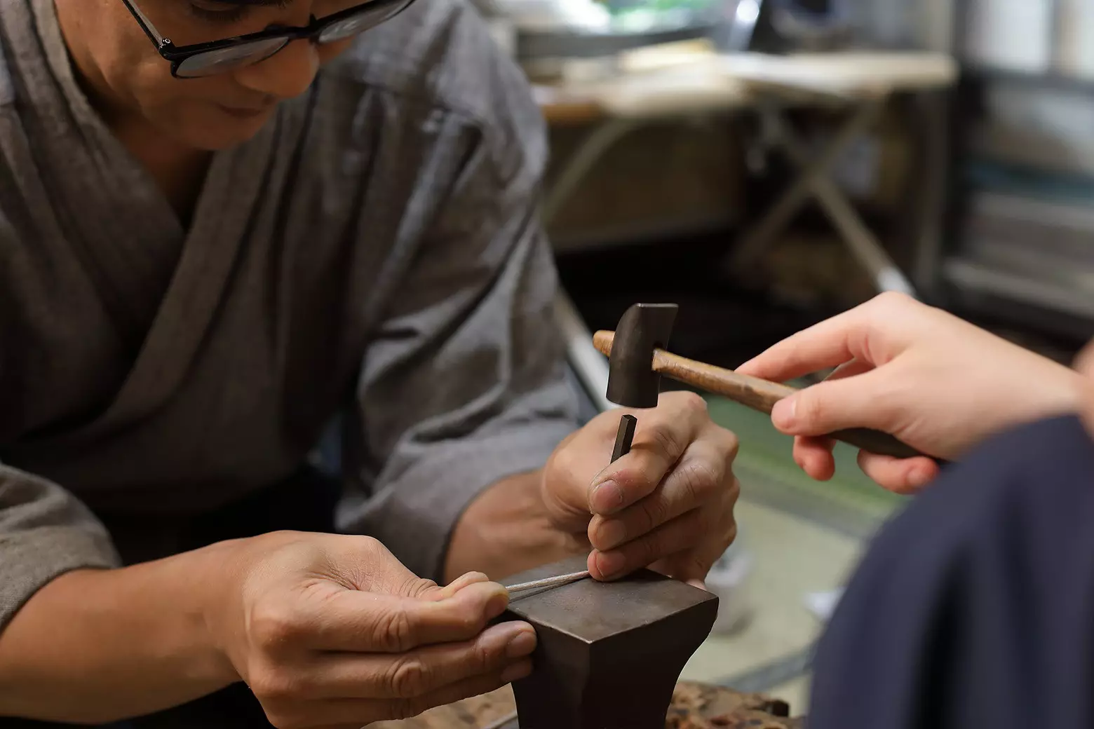 Yoshitsugu Kamikawa helps a participant make a silver bangle