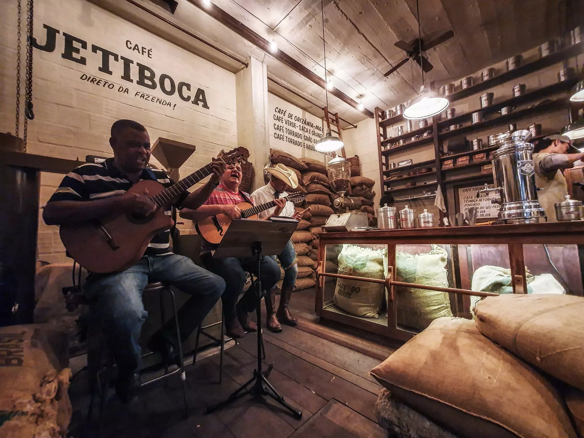 Two guitarists singing and playing in a cafe