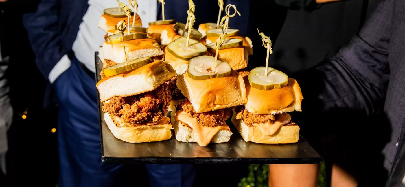 A tray of small sandwiches with toothpicks.