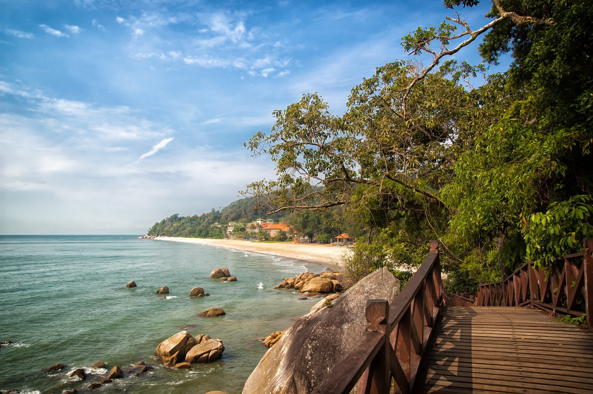 Stunning nature of Kuantan. Best Kuantan beach resorts famous for pristine nature. Coastline with tropic nature plants sand beaches. Bridge or wooden pier at sea lagoon with rocks and waves.
