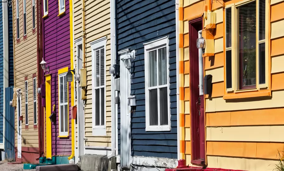 Row of brightly painted clapboard houses in St John's, Newfoundland, in yellow, navy, purple and orange