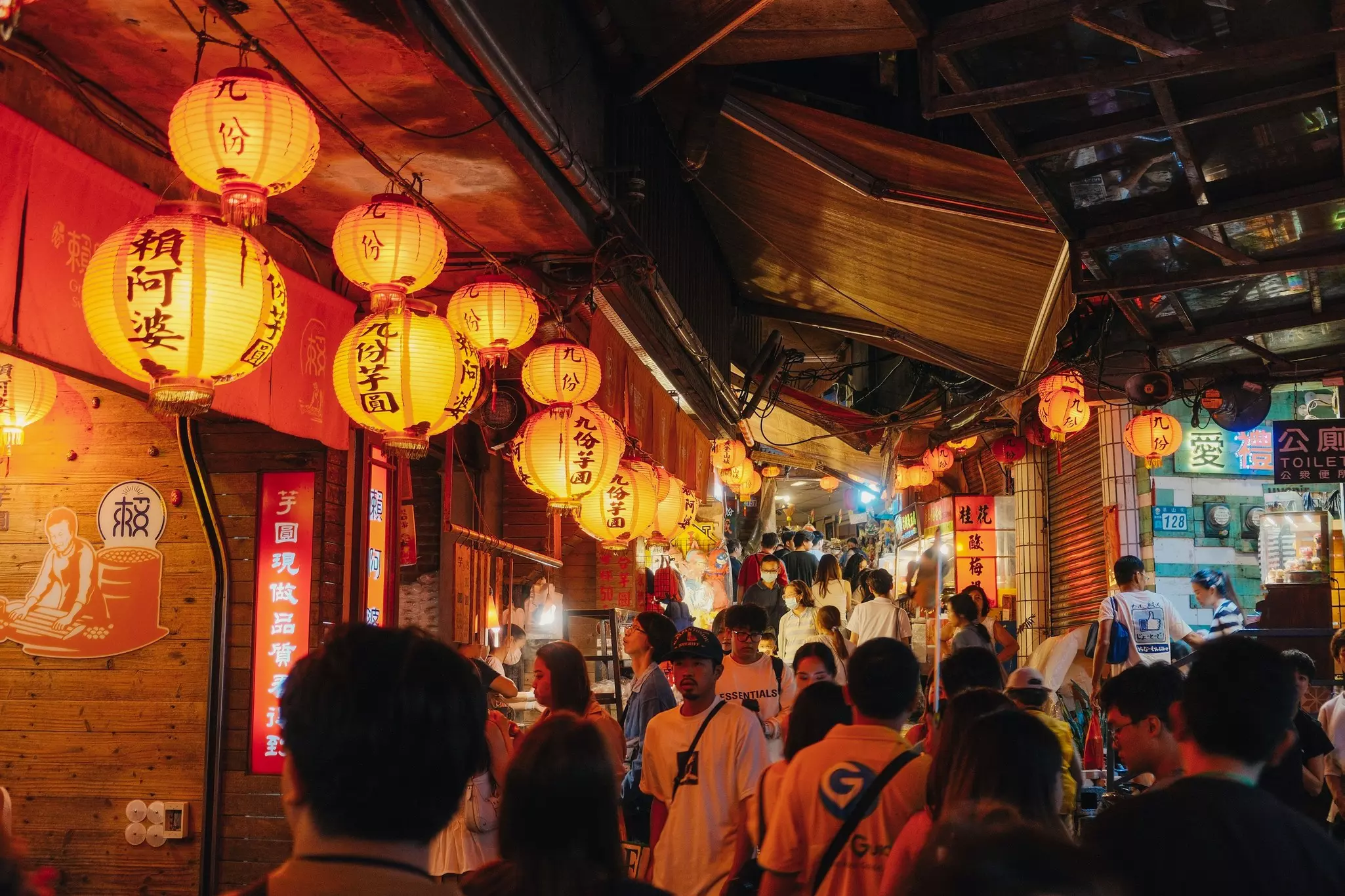 Alleys of the old town filled with people during night time with stores lined up with lanterns hanging in New Taipei district