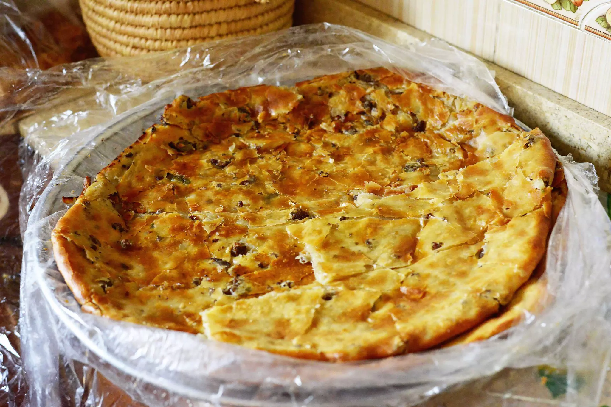 Egyptian-style fiteer, a flaky, buttery layered pastry, on a shop counter.