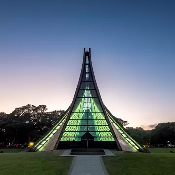 The Luce Memorial Chapel a tee pee shaped structure glows green in twighlight