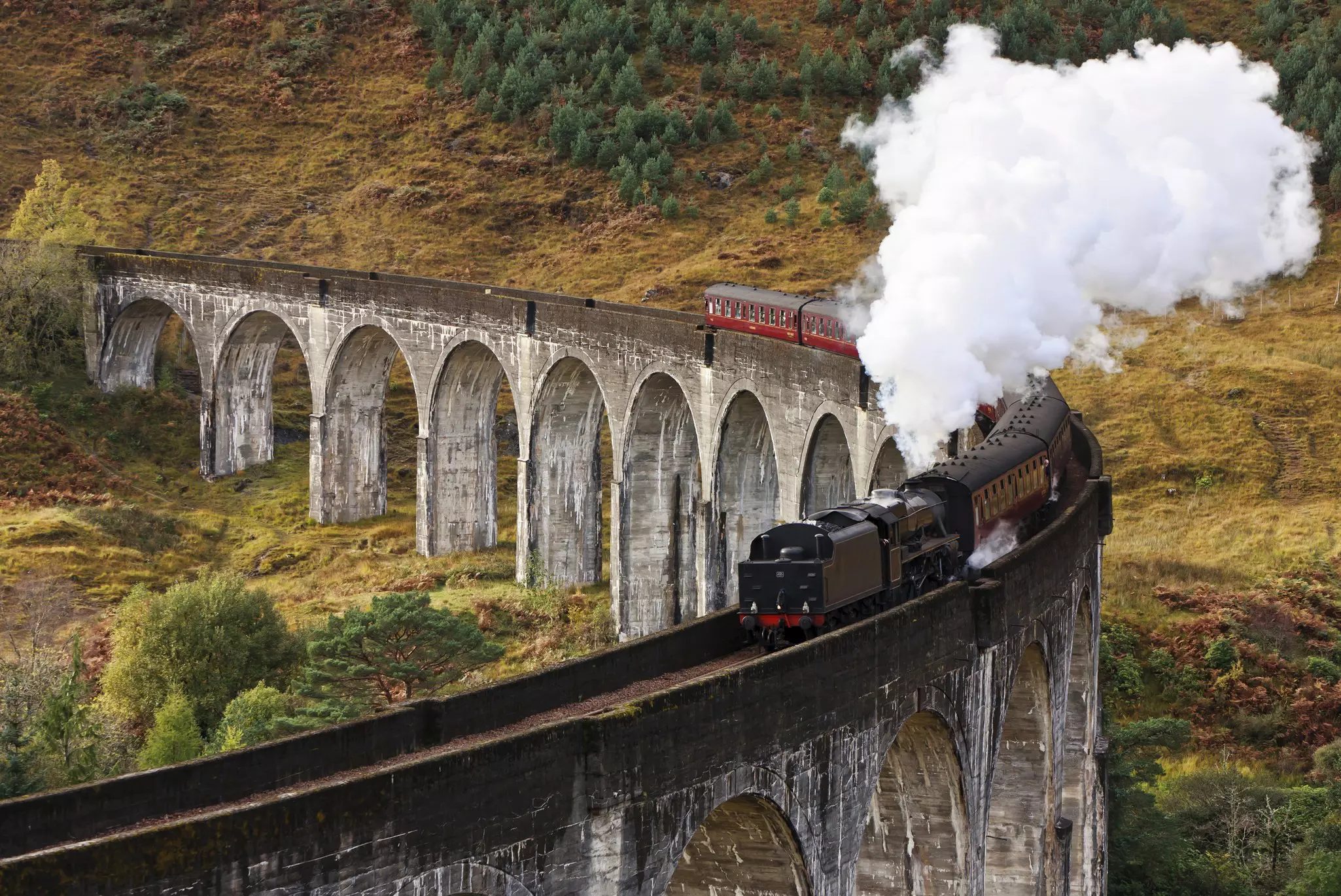 Jacobite Express train crossing a curved viaduct at Glenfinnan.