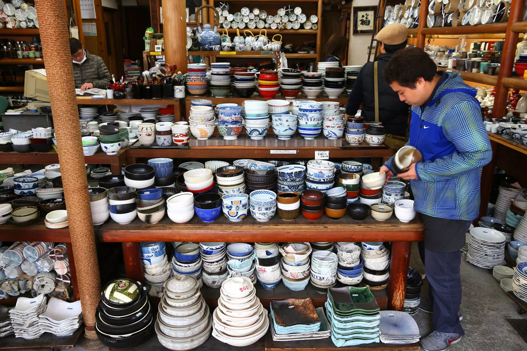 A shopper looks at Japanese ceramics stacked in a display in Tokyo.