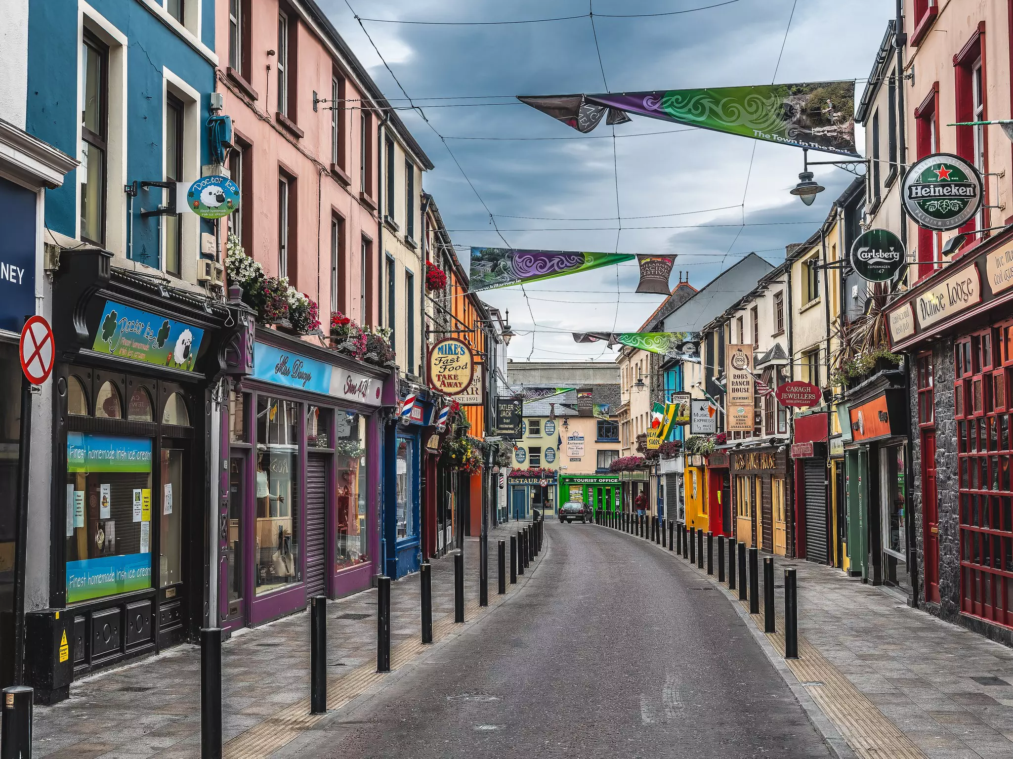A town street lined with colorful shops with flags flying above.