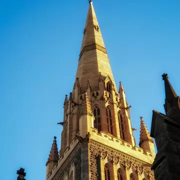 The spire of St Paul’s Cathedral photographed against a clear blue sky in the evening light. Melbourne, Australia.