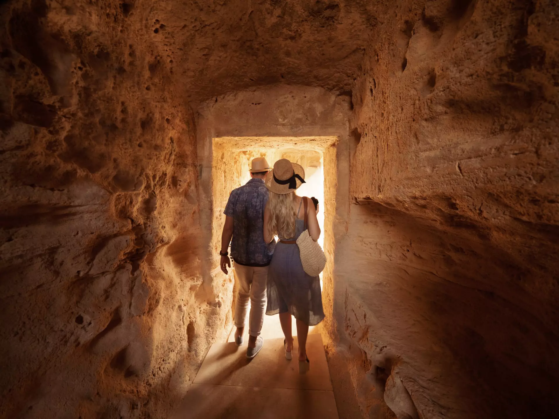 Man and woman walking through tunnel at the Tombs of the Kings
964890890