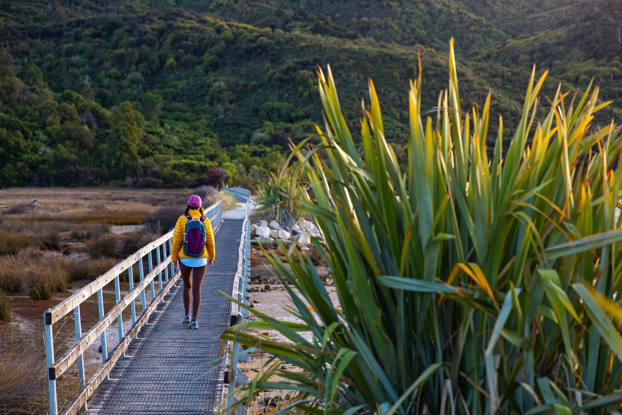 A hiker on the wooden bridge at the start of the Abel Tasman Coast Track