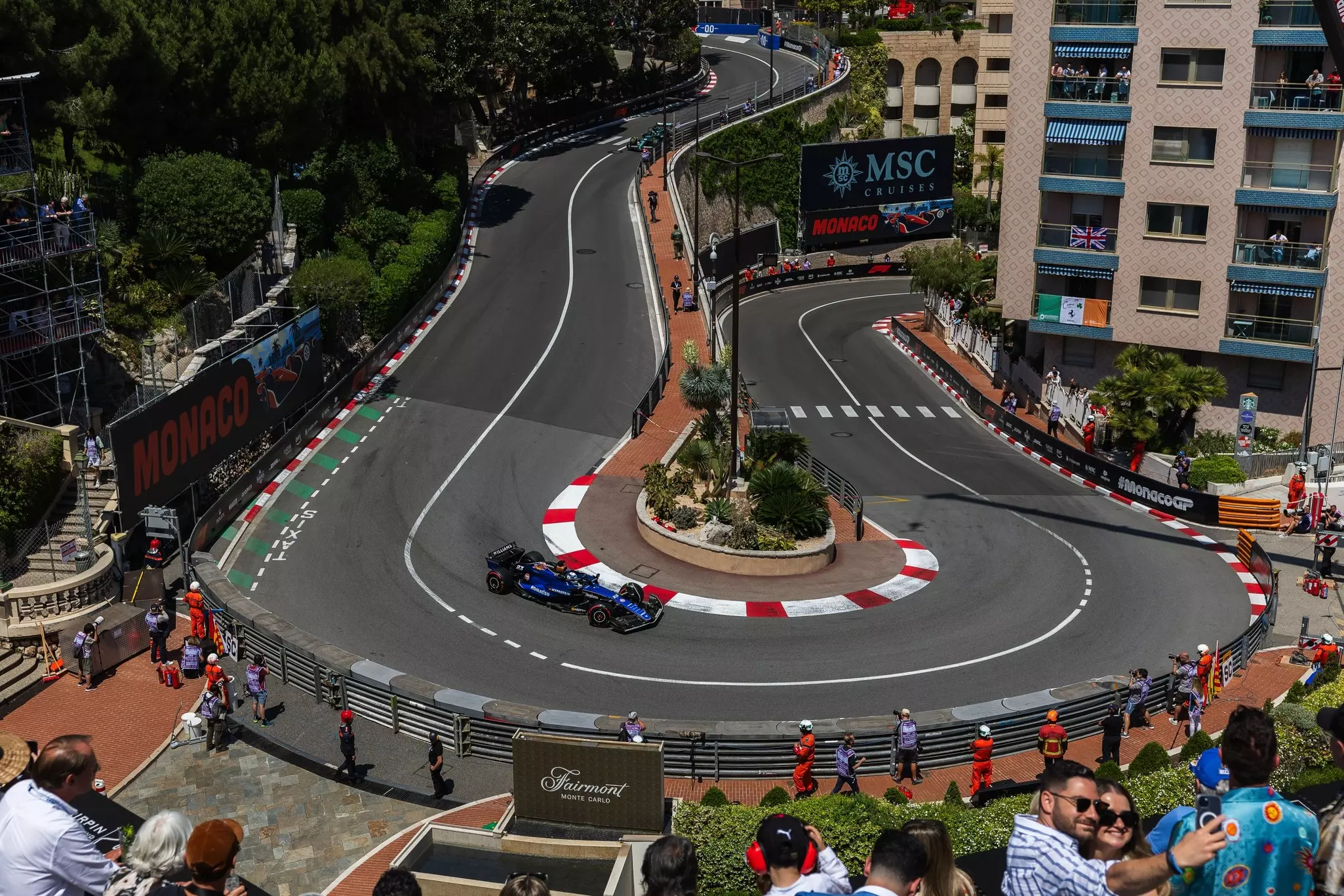 A race car navigates a hairpin turn on a city street.