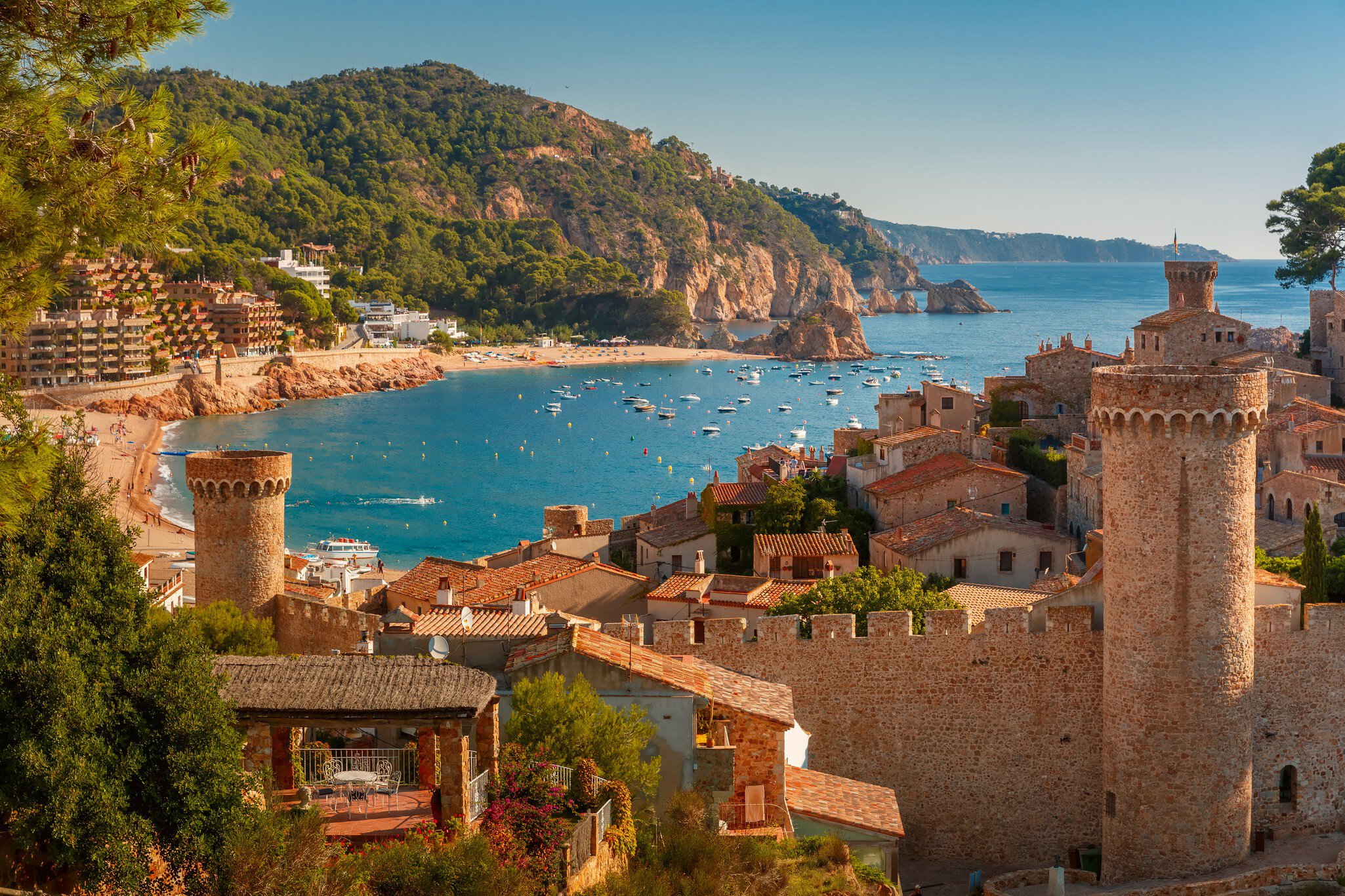 A tan brick fortress overlooking a blue-watered bay
