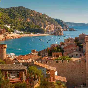 A tan brick fortress overlooking a blue-watered bay