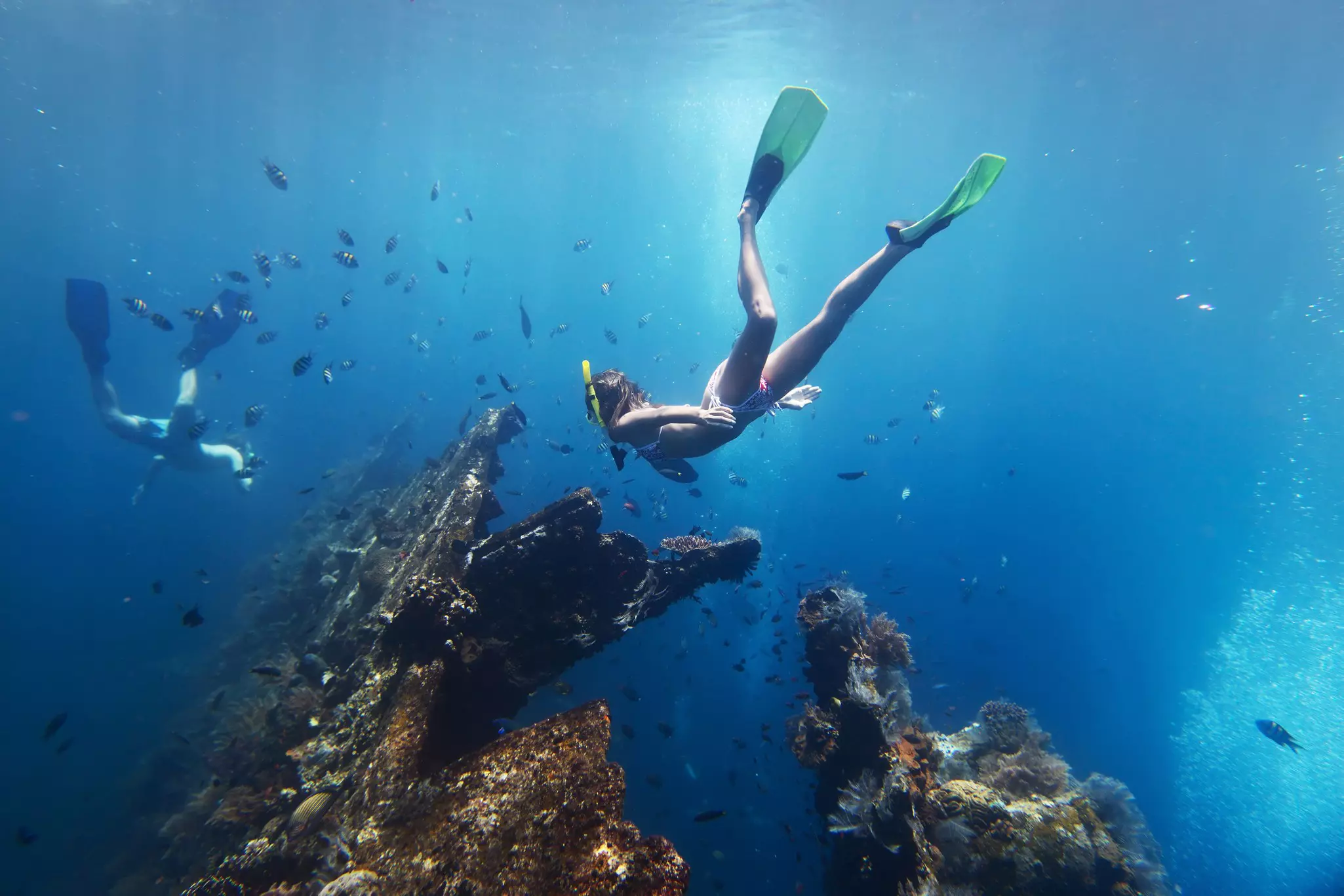 Snorkelers diving to view the wreck of the USAT Liberty at Tulamben, Bali Indonesia.